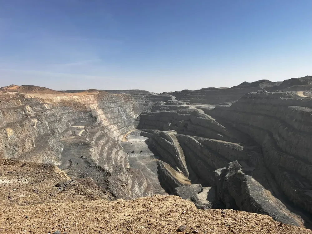 Open pit mine in the desert under a clear blue sky