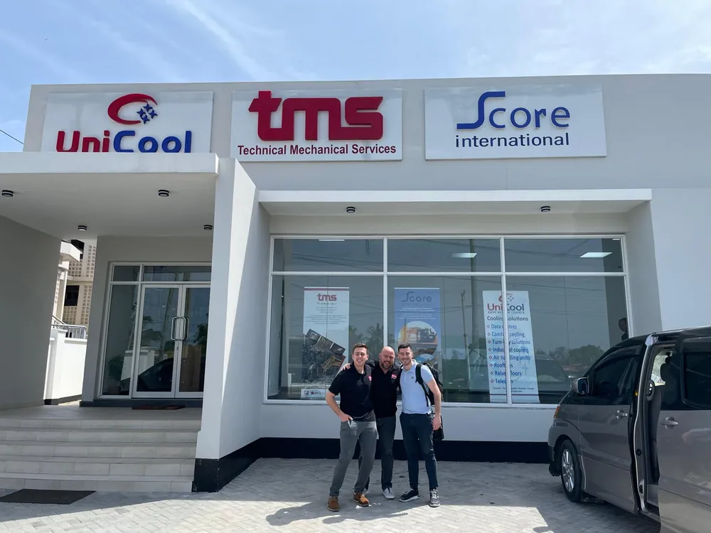 Three TMS team members in front of the TMS office in Tanzania
